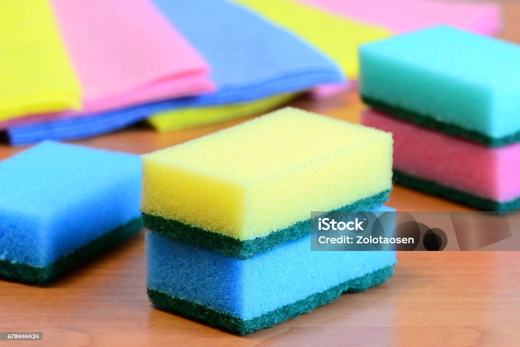 Colorful sponge and rags for cleaning ware and house cleaning Cleaning sponge with scrub and rags set on a wooden table. Closeup Bathroom Stock Photo