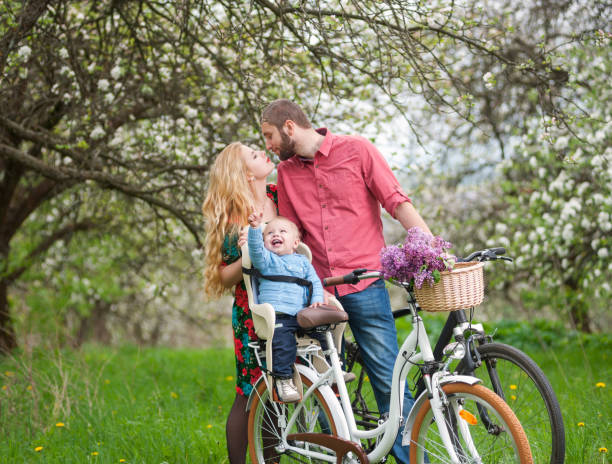 istock Young family on a bicycles in the spring garden 678453802