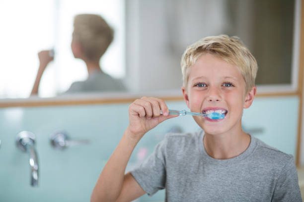 istock Portrait of boy brushing his teeth in bathroom 678455920