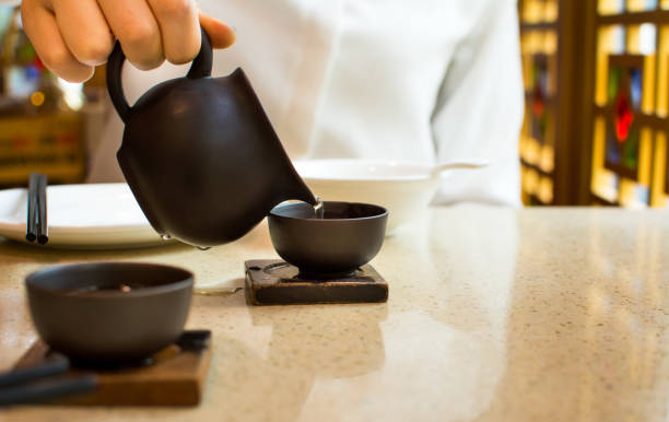 istock Female pouring tea into ceramic teacup 678464654