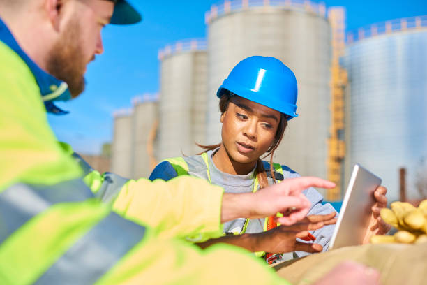 discussing the problem two site engineers discussing a project down at the dock yard storage tank photos stock pictures, royalty-free photos & images