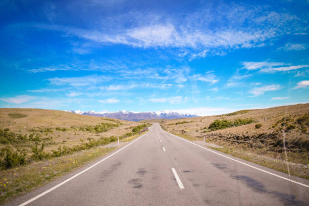 istock Open road through landscape to snow covered mountains 678480618