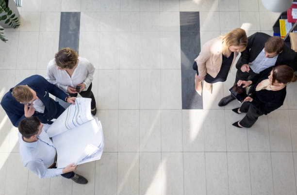 istock High angle view of business people in office hallway 678483152