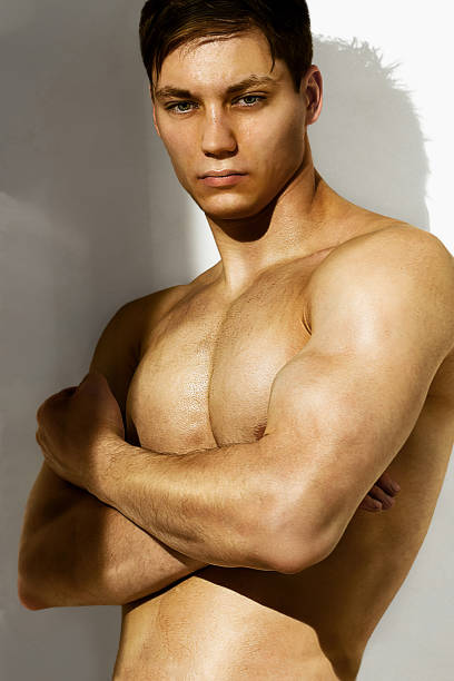 Young tanned male athlete doing exercise outdoors on a sunny day