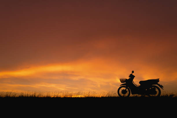 istock Orange sunset sky. Silhouette motorcycle in sunset landscape backdrop 678496740