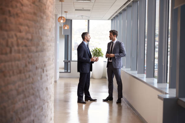 istock Two Businessmen Having Informal Meeting In Office Corridor 678500268