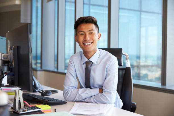 istock Portrait Of Young Businessman At Office Desk Using Computer 678500578