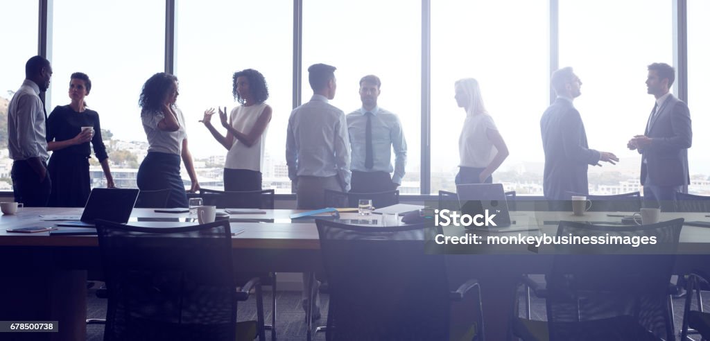 Businesspeople Stand And Chat Before Meeting In Boardroom Business Person Stock Photo