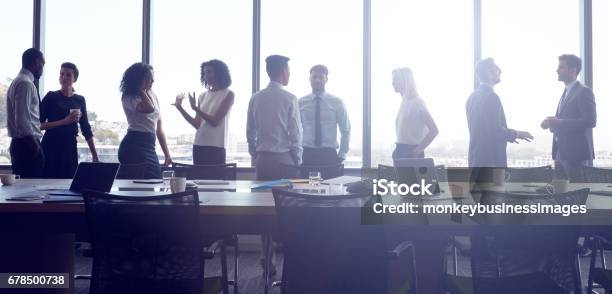 Businesspeople Stand And Chat Before Meeting In Boardroom Stock Photo - Download Image Now