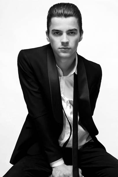 istock handsome young man in  suit sitting on  white background 678502266