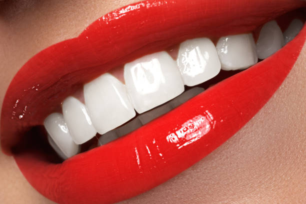 istock Macro happy woman's smile with healthy white teeth, red lips 678507624
