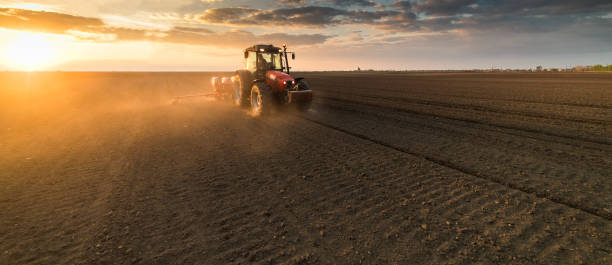 istock Farmer with tractor seeding - sowing crops at agricultural fields in spring 678508496