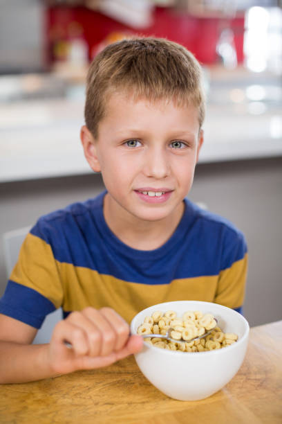 istock Portrait of smiling boy having breakfast cereal in kitchen 678508556