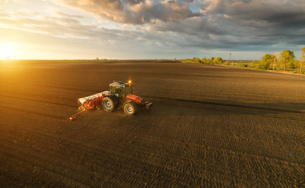 istock Farmer with tractor seeding - sowing crops at agricultural fields in spring 678508686