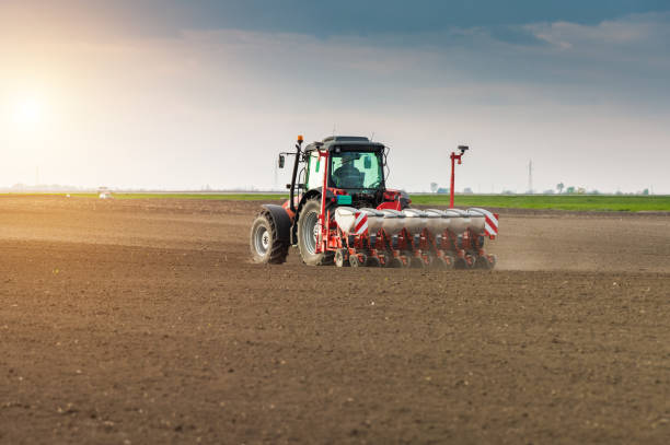 istock Farmer with tractor seeding - sowing crops at agricultural fields in spring 678508828