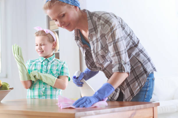 istock Woman wiping a table and her daughter helping her 678508836