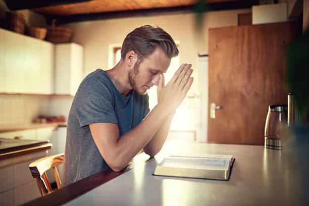 going through his daily devotions - bible holding reading book imagens e fotografias de stock