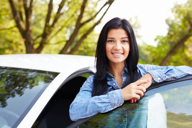istock Woman standing and leaning on car door 678513106