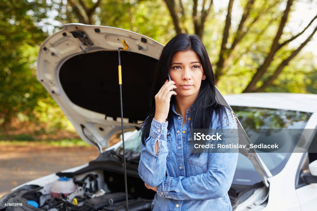 Young woman with a broken car Woman with a broken car calling for assistance Vehicle Breakdown Stock Photo