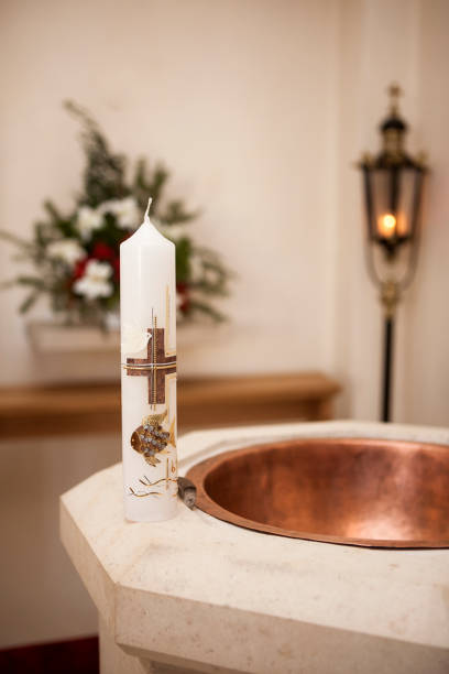 Baptismal candle on font Baptismal candle on font in church, indoor pics of the godmother stock pictures, royalty-free photos & images