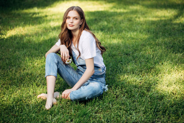 istock Beautiful woman sitting on the grass 678535776