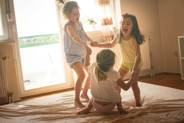 istock Three little girls having fun on bed. 678551142