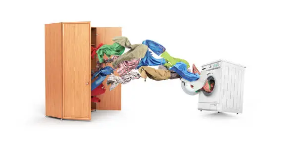 Photo of Clothing flies out of the cupboard into the washing machine isolated on white background