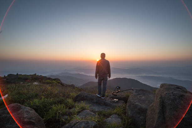istock man standing on rock with photography kit 678556832
