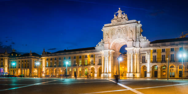 Warm lamplight illuminating the Praca do Comercio after sunset, the landmark square overlooked by the historic Rua Augusta Arch in the heart of Lisbon, Portugal’s vibrant capital city.