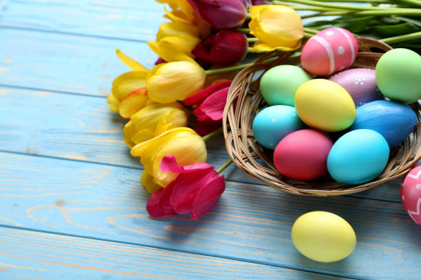 istock Easter eggs with tulips on a blue wooden table 678577178