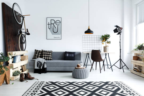 White living room with sofa Hipster style, white living room with sofa, pouf, carpet, bike monochrome house stock pictures, royalty-free photos & images