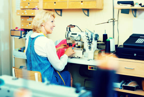 istock Mature woman sewing with professional machine 678594578