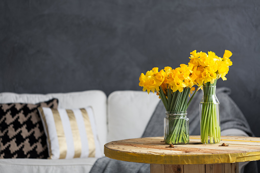 Daffodils on a table and white sofa in living room