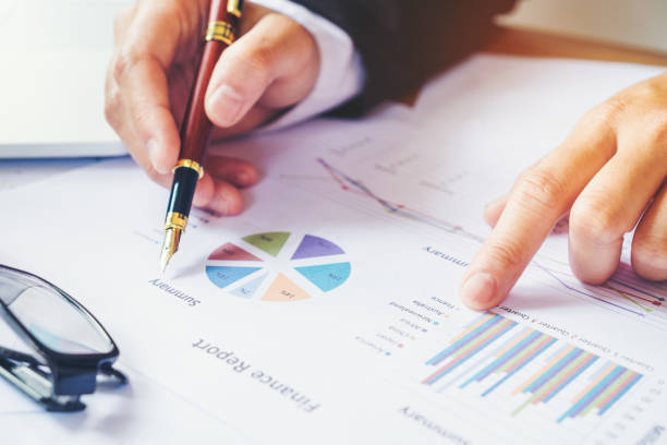 istock business man holding pen pointing on summary report chart 678603022