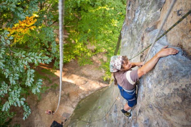 istock Woman rock climber is climbing on a rocky wall 678606718