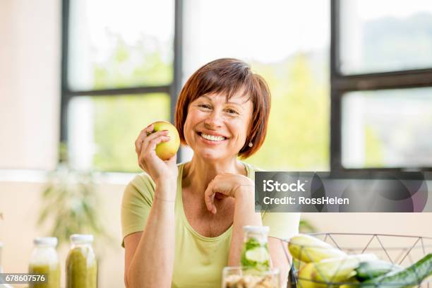 Mujer Mayor Con Alimentos Saludables En Interiores Foto de stock y más banco de imágenes de Comer - Comer, Tercera edad, Mujeres mayores