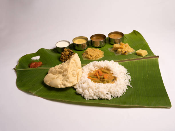 south indian meals served in a banana leaf on white background south indian meals served in a banana leaf on white background tamil nadu stock pictures, royalty-free photos & images