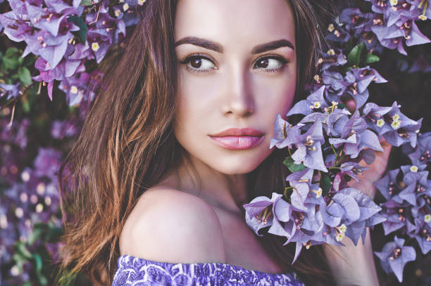 istock Beautiful young woman surrounded by flowers 678628992