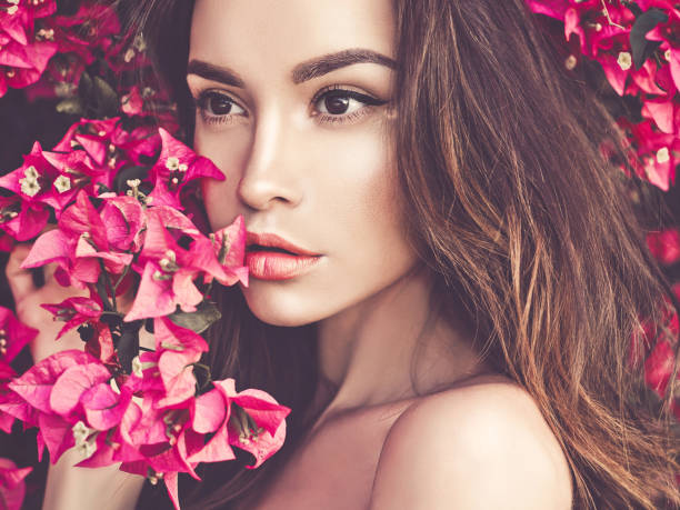 istock Beautiful young woman surrounded by flowers 678629084
