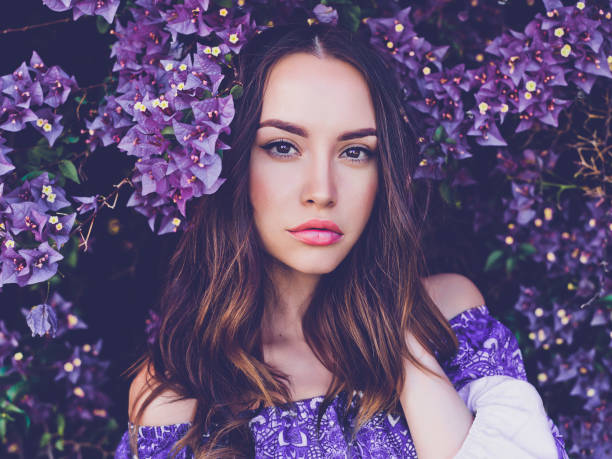 istock Beautiful young woman surrounded by flowers 678635030