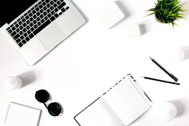 istock Stylish minimalistic workplace with laptop keyboard, notebook, sunglasses and office plant in flat lay style. White background. Top view. 678651792