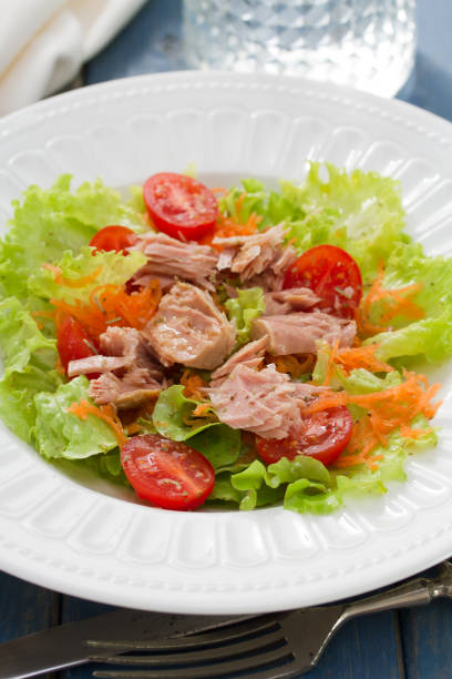 istock fish salad on white plate on blue background 678652164