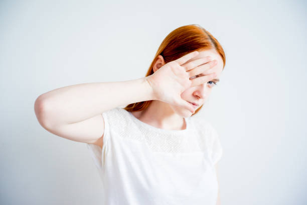 Girl is covering her face with her hand