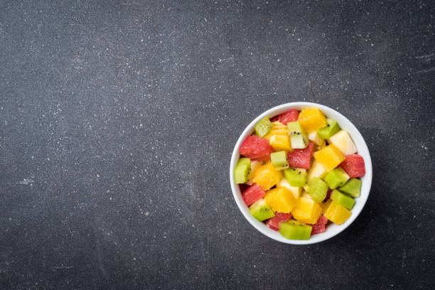 istock Colorful fruit salad on gray stone table. 678653626