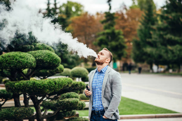istock Man vape electronic cigarette outdoor 678656646