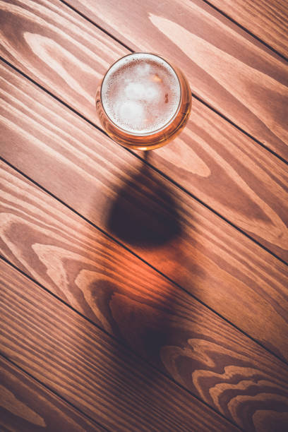 Overhead shot of beer glass on wooden table.