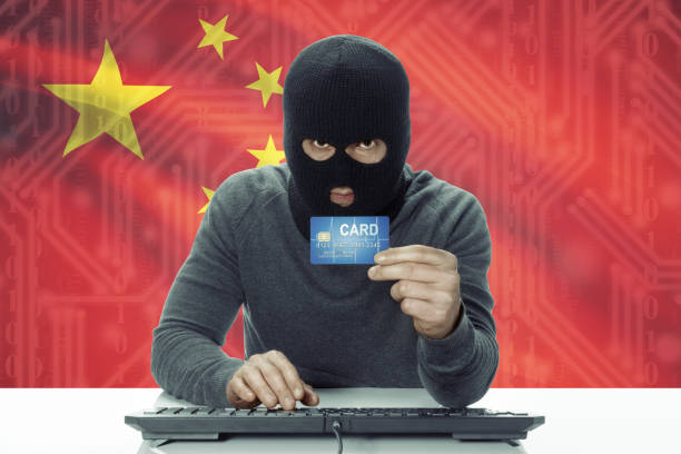 istock Dark-skinned hacker with flag on background holding credit card - China 678685422