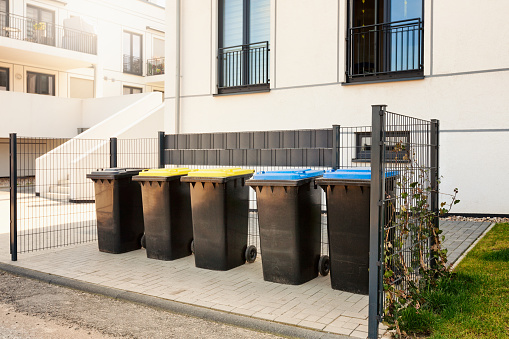 Recycle, waste and garbage bins near new residential apartment building, environmental protection