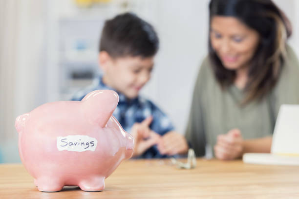 istock Mom teaches her son to save money 678696880