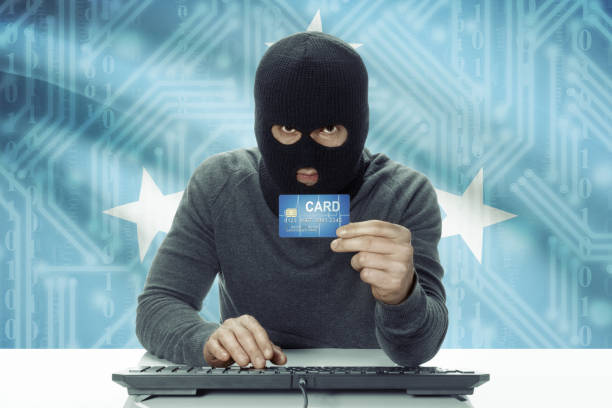 istock Dark-skinned hacker with flag on background holding credit card - Micronesia 678699104